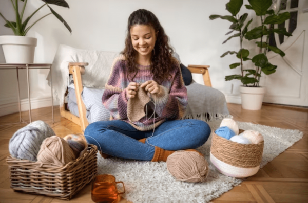 Person knitting with yarn in a cozy living room